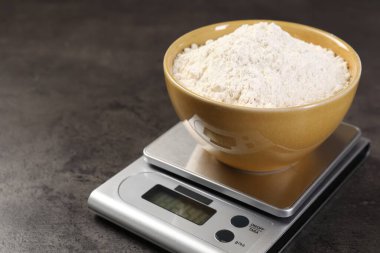 Dijital mutfak terazisi ve bir kase un, yakın plan. Metin için boşluk