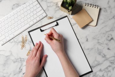 Beyaz mermer masadaki panoya yazı yazan kadın, üst görünüm