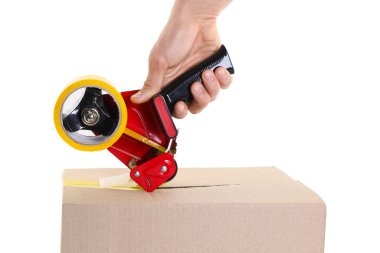 Beyaz arkaplanda karton kutuyu mühürlemek için yapıştırıcı bantlı şeker kutusu kullanan adam.