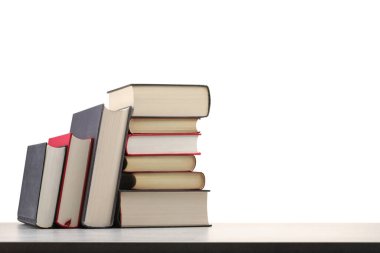 Açık gri masadaki eski kitaplar beyaz arkaplana karşı