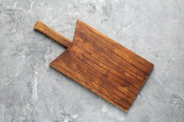 Açık gri desenli bir masada ahşap servis tahtası, üst manzara. Metin için boşluk