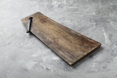 Açık gri desenli bir masada ahşap servis tahtası, yakın plan. Metin için boşluk