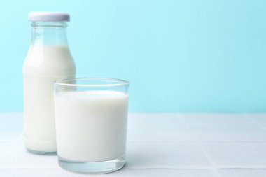 Açık mavi arka planda beyaz masada taze süt. Metin için boşluk