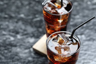 Kolayı buz küpleriyle tazelemek ve koyu dokulu masada pipetler, yakın plan. Metin için boşluk