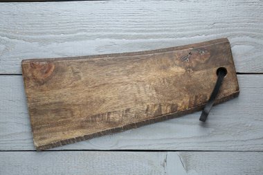 Gri ahşap masada bir tahta kesme tahtası, üst manzara.