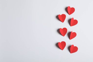 Açık gri arkaplanda bir sürü kağıt kalp, düz bir zemin. Metin için boşluk