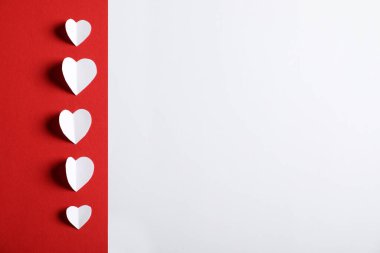 Beyaz zemin üzerinde kağıt kalpler olan kırmızı çarşaf, düz yatıyordu. Metin için boşluk