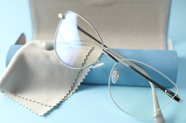Açık mavi arka planda şık gözlüklü ve temiz giysili çanta, yakın plan