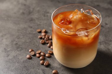 Gri masada lezzetli buzlu kahve ve fasulye, yakın plan. Metin için boşluk