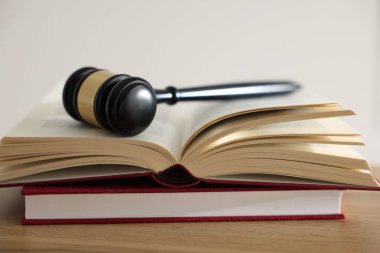 Yargıç tokmağı ve kitaplar kapalı bir masa üzerinde, yakın plan.