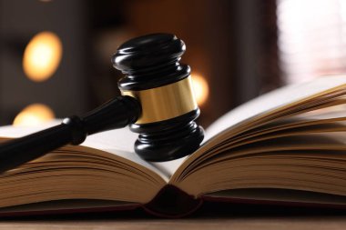 Yargıç tokmağı ve kitabı kapalı bir masa üzerinde, yakın plan.