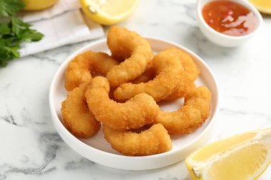 Lezzetli tempura karidesleri ve limon beyaz mermer masada, yakın plan.