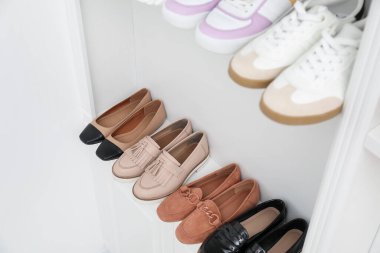 Ayakkabı deposu. İçerideki raflarda farklı ayakkabılar, yakın plan.