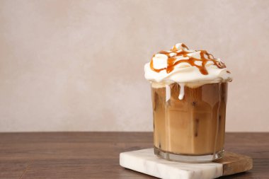 Krem şantili ve ahşap masadaki şuruplu lezzetli buzlu kahve. Metin için boşluk