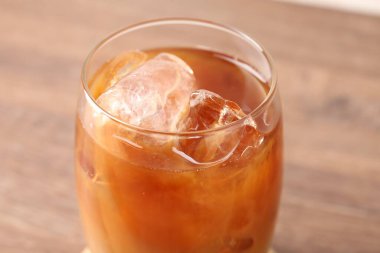 Ahşap masada lezzetli buzlu kahve, yakın plan.