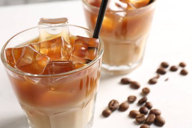 Lezzetli buzlu kahve ve fasulyeler beyaz masada, yakın plan.