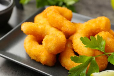 Gri desenli masada lezzetli tempura karidesleri ve maydanozlar. Yakın plan.