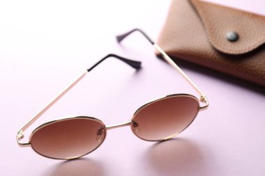 Mor arka planda şık gözlüklü çanta, yakın plan