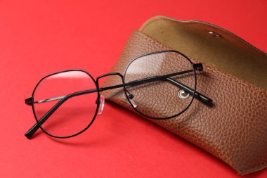 Kırmızı arka planda şık gözlüklü çanta, yakın plan