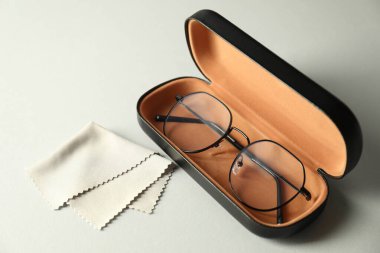 Şık gözlüklü çanta ve açık arkaplanda temizlik bezi.