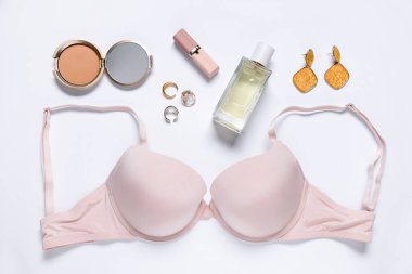 Beyaz zemin üzerinde pembe sutyen ve kozmetik ürünler ile düz konum