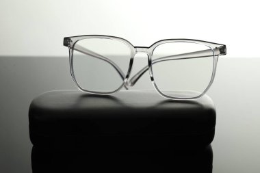 Beyaz ayna yüzeyinde şık gözlükler ve çanta, yakın plan.