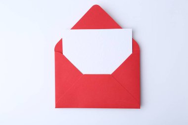 Beyaz zemin üzerinde kırmızı kağıt zarf içinde boş tebrik kartı, üst görünüm