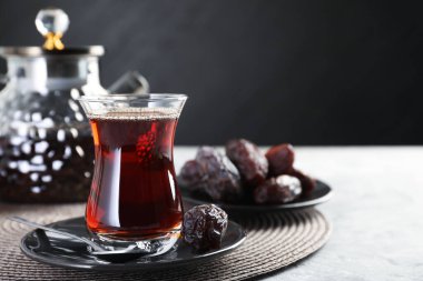 Geleneksel Türk çayı cam fincanda, çaydanlıkta ve açık gri masada, yakın plan. Metin için boşluk