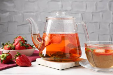 Aromatik çilekli meyve çayı ve beyaz mermer masada nane.