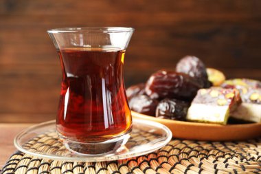 Tahta masada şekerlerle servis edilen lezzetli Türk çayı, yakın plan.