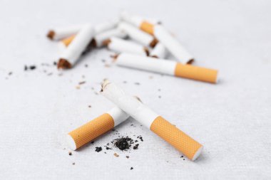 Many cigarette butts on light background, closeup