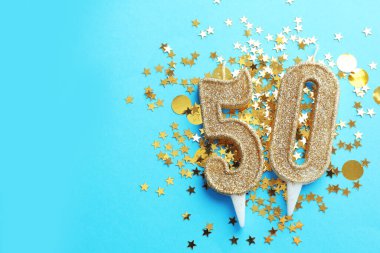 50. yaş günü. Açık mavi arkaplandaki mumlar ve konfetiler düzdü. Metin için boşluk