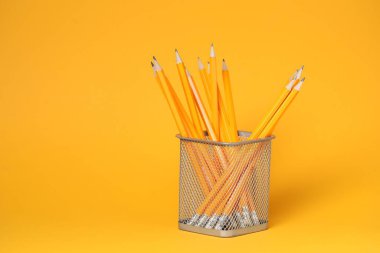 Turuncu arkaplanda çok sayıda kalem, metin için boşluk