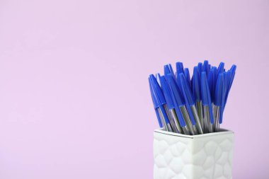 Pembe arka planda bir sürü tükenmez kalem var, yakın plan. Metin için boşluk