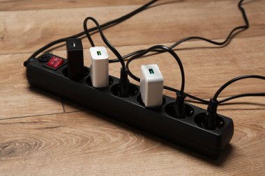 Uzatma güç panosu ahşap zemindeki prizlerle aşırı yüklendi