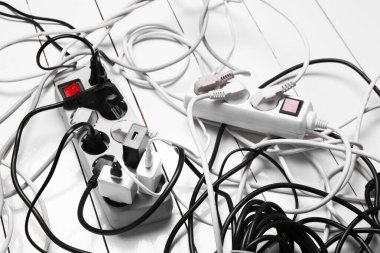 Uzatma güç panoları ahşap zemindeki tıkaçlarla aşırı yüklenmiş, yakın plan.