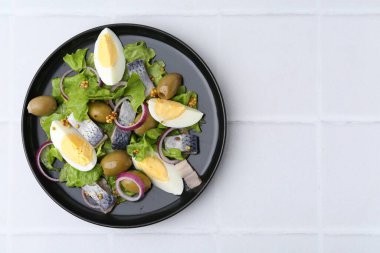 Ringa balıklı lezzetli salata, yumurta, hardal ve sebzeler beyaz fayanslı masa, üst manzara. Metin için boşluk
