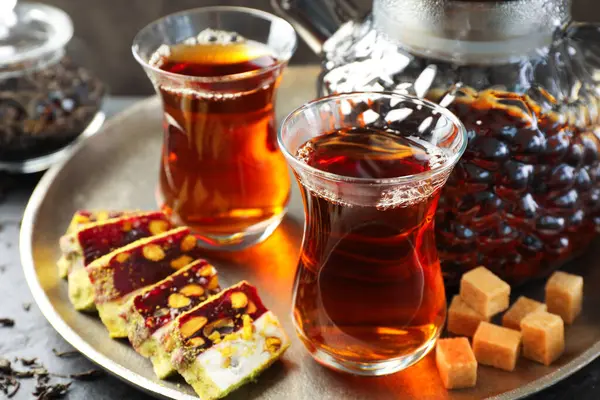 Lezzetli Türk çayı ve zevki siyah masada, yakın plan.