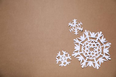 Kahverengi arka planda güzel kar taneleri, düz bir zemin. Metin için boşluk