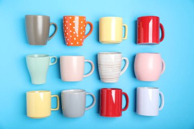 Açık mavi arkaplanda bir sürü renkli fincan, düz yatıyordu.