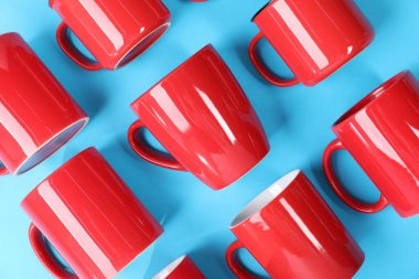 Açık mavi arkaplanda bir sürü renkli fincan, düz yatıyordu.