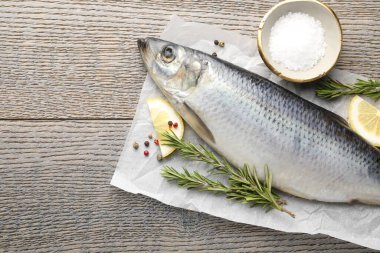 Salamura ringa balığı ve baharatlar ahşap masada, düz yerde. Metin için boşluk