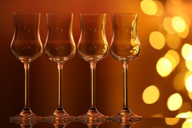 Bulanık ışıklara karşı cam ayna yüzeyinde birçok temiz bardak var. Bokeh etkisi