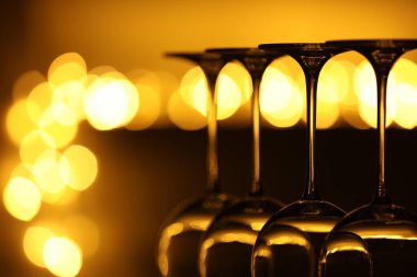 Bulanık ışıklara karşı birçok temiz bardak, yakın plan. Bokeh etkisi