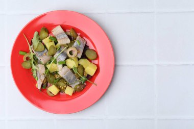 Beyaz fayanslı masada ringa balıklı nefis salata, üst manzara. Metin için boşluk