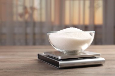 Dijital mutfak terazisi, içinde bir kase şeker olan kapalı masa, yakın plan. Metin için boşluk