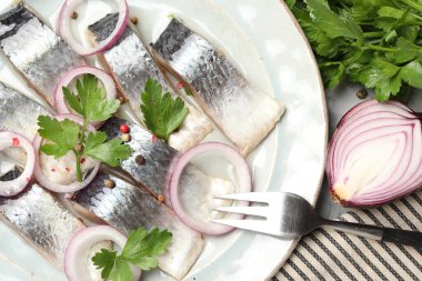 Masada servis edilen baharat ve soğanlı lezzetli ringa balıkları.