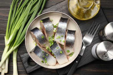 Lezzetli ringa balıkları. Yeşil soğanlı. Siyah ahşap masada servis ediliyor.