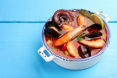 Lezzetli deniz ürünleri çorbası mavi ahşap masada, yakın plan. Metin için boşluk