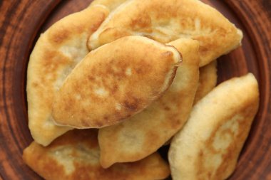 Lezzetli kızarmış pirizky (doldurulmuş turtalar) tabakta, üst görünümde.